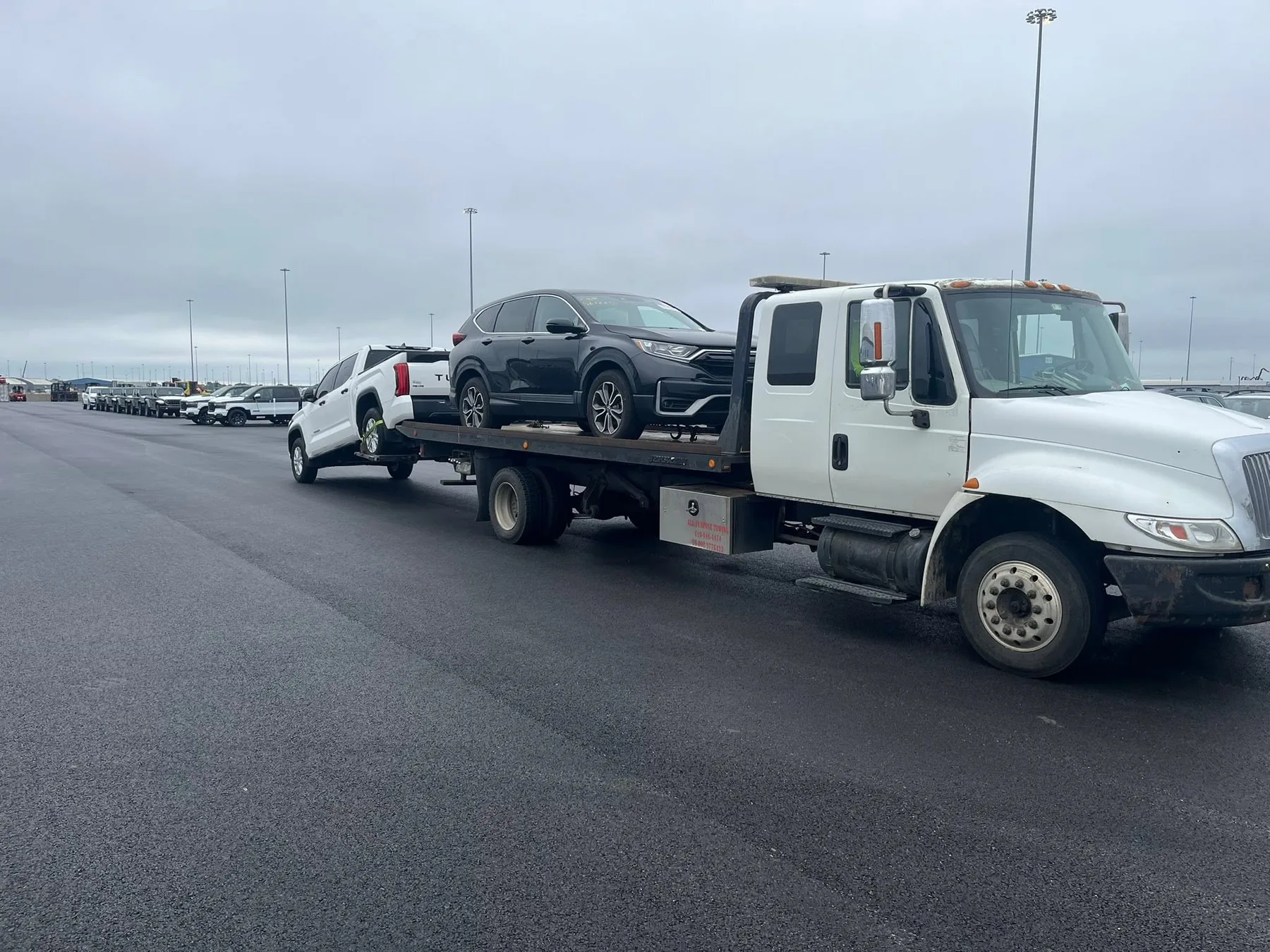 Statewide Recovery Service flatbed transporting an SUV with another vehicle in tow